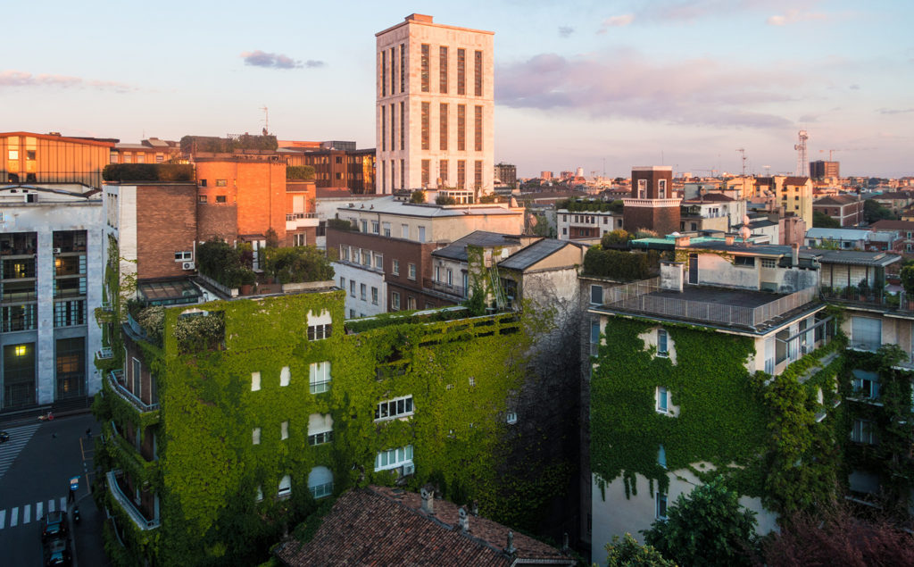 Paysage urbain avec mur vivant et grand bâtiment au crépuscule à Milan.