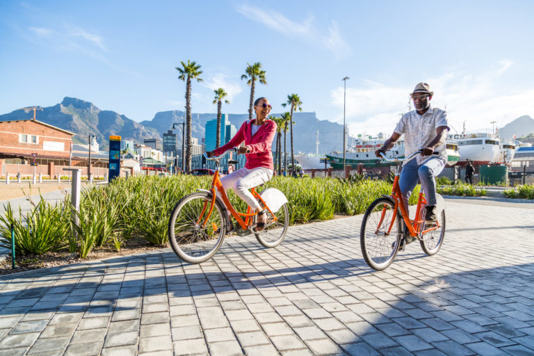 Couple sightseeing on hired bicycles in city, Cape Town