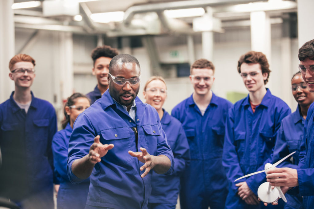Un tuteur enseigne à sa classe les énergies renouvelables dans un atelier d'ingénierie.