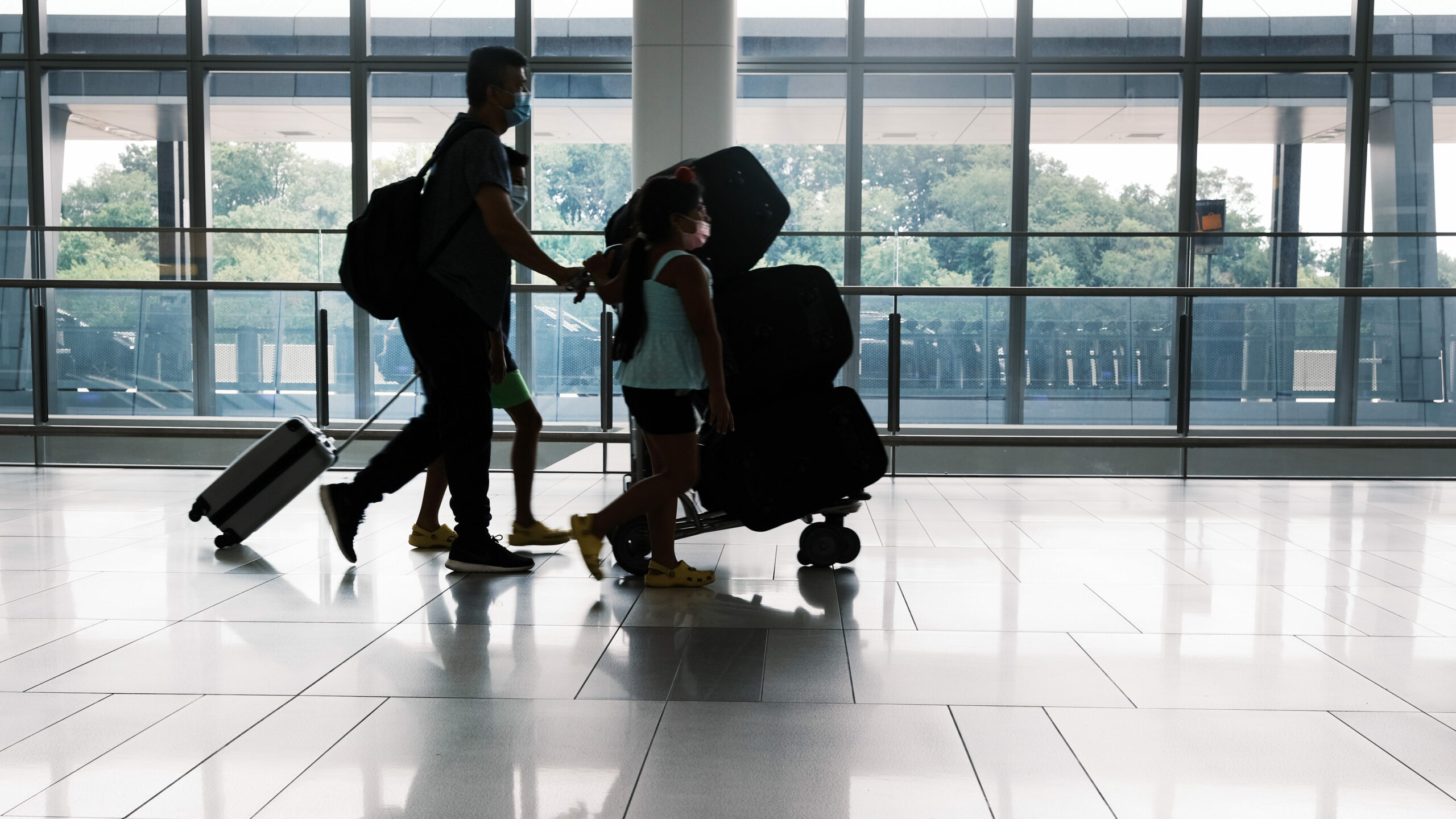 People travelling through through an airport with lugagge