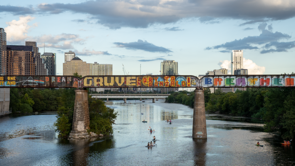 Sur la photo : un pont dans la ville d'Austin au-dessus d'un ruisseau avec des bâtiments en arrière-plan.