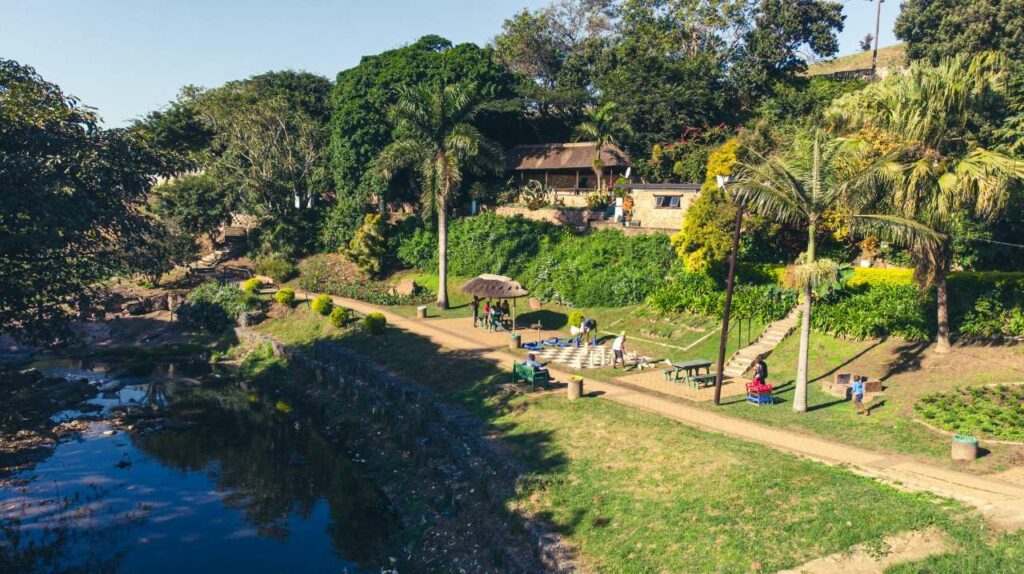 Durban (eThekwini) river restoration project site showing a riverside, trees, green space along a path and locals enjoying outdoor space.