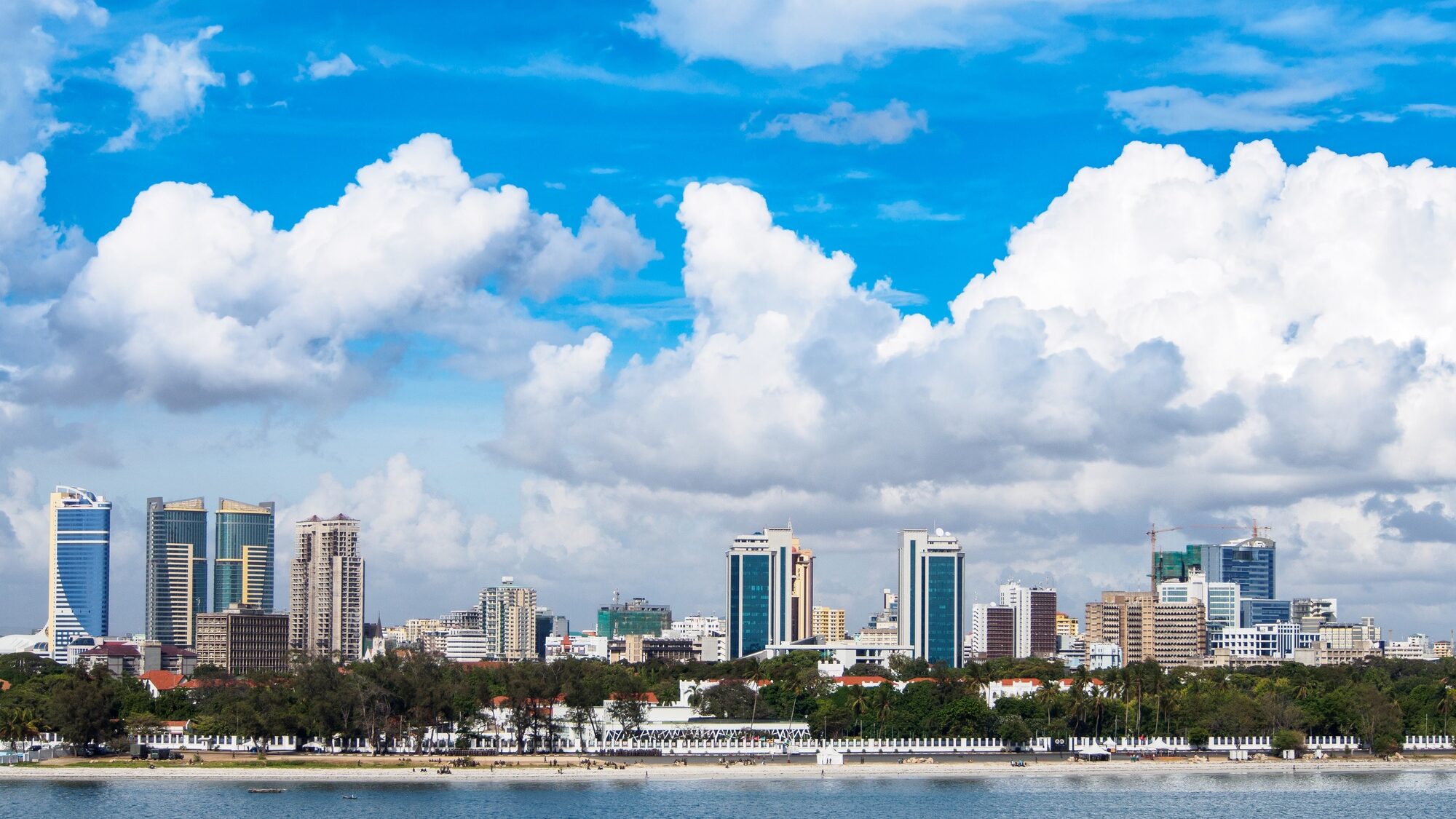 Photo Taken In Dar Es Salaam, Tanzania. showing the city skyline on a sunny day with clear blue skies and some clouds.