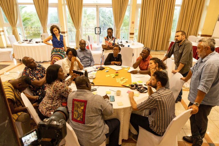 Roundtable of city representatives from Accra in deep conversation.