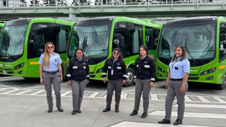 Image of 5 female bus drivers standing in front of 3 electric buses.
