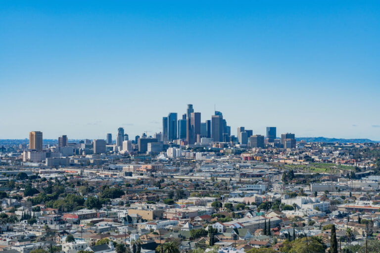 Photo of cityscape view of city of Los Angeles, with residential homes and downtown Los Angeles in the background.