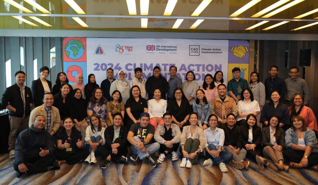 Delegates in a goup photo sitting on the floor and standing